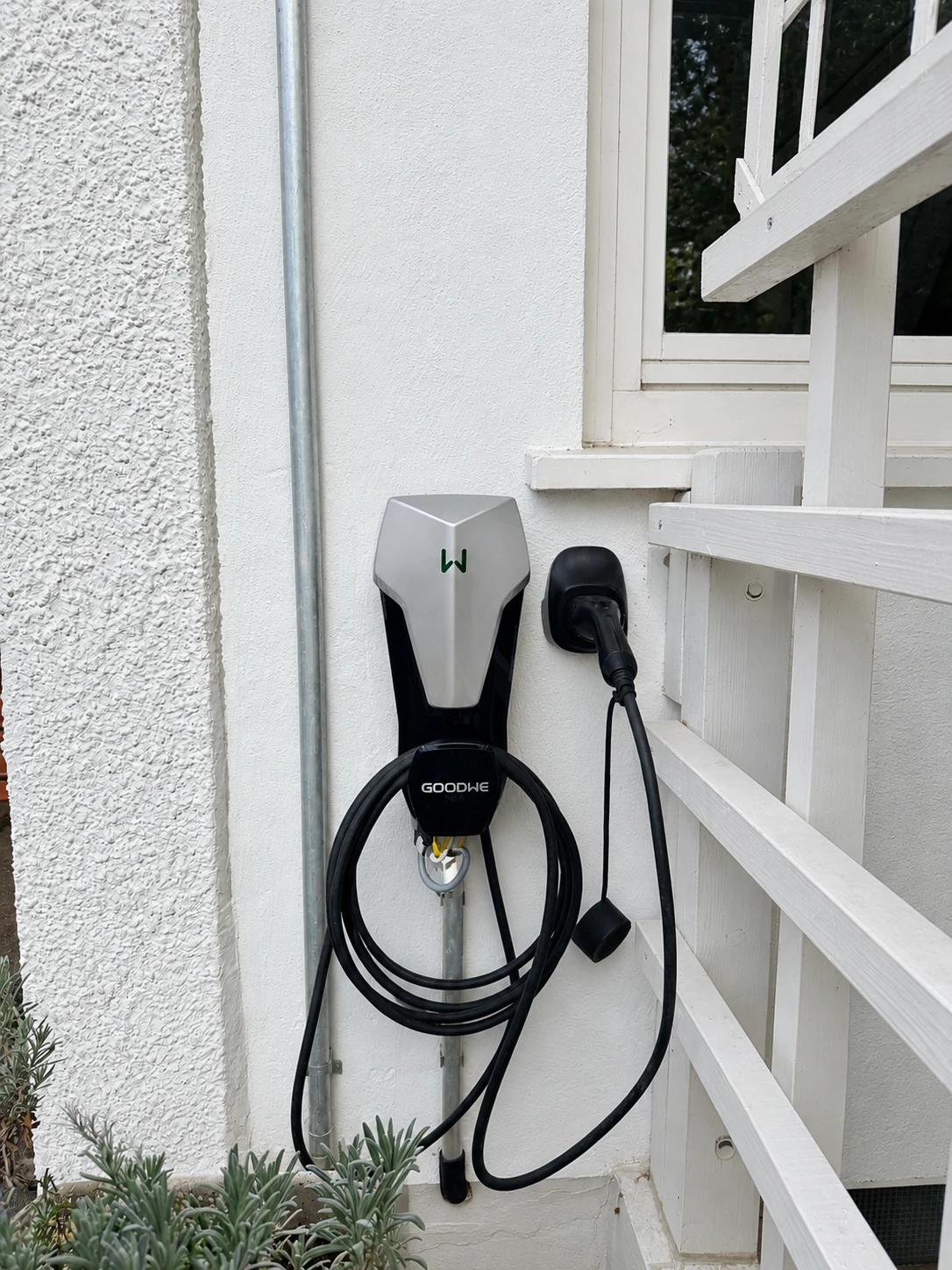 GoodWe-Wallbox mit aufgewickeltem Ladekabel an einer Hauswand